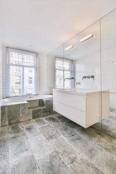 Luxurious bathroom with marble floor and bathtub near the window