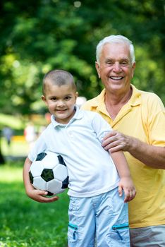 happy grandfather and child have fun and play in park on beautiful  sunny day