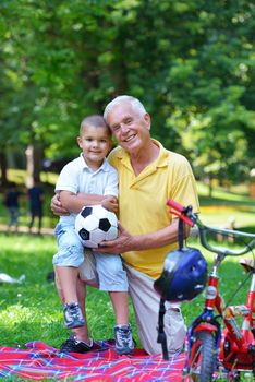 happy grandfather and child have fun and play in park