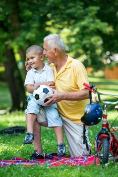 happy grandfather and child have fun and play in park on beautiful  sunny day