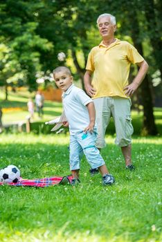 happy grandfather and child have fun and play in park on beautiful  sunny day