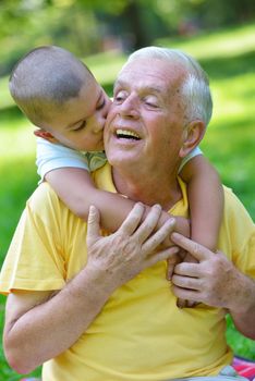 happy grandfather and child have fun and play in park