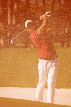 golf player shot ball from sand bunker at course