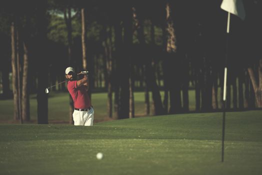 golf player shot ball from sand bunker at course