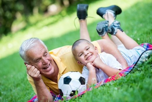 happy grandfather and child have fun and play in park on beautiful  sunny day