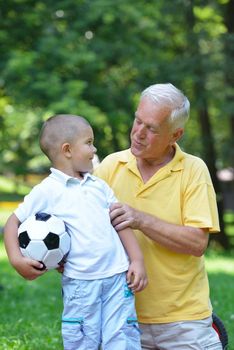 happy grandfather and child have fun and play in park