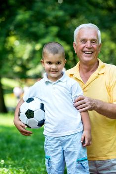 happy grandfather and child have fun and play in park on beautiful  sunny day