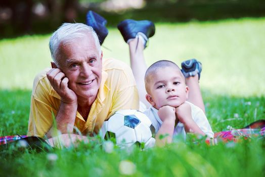 happy grandfather and child have fun and play in park on beautiful  sunny day