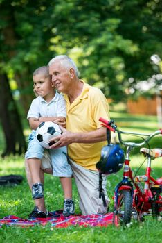 happy grandfather and child have fun and play in park on beautiful  sunny day