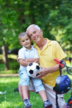 happy grandfather and child have fun and play in park