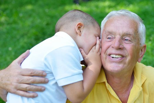 happy grandfather and child have fun and play in park