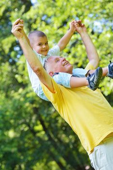 happy grandfather and child have fun and play in park