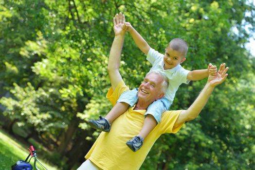 happy grandfather and child have fun and play in park