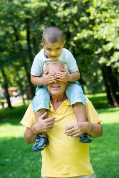 happy grandfather and child have fun and play in park on beautiful  sunny day