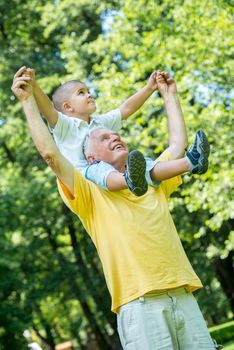 happy grandfather and child have fun and play in park on beautiful  sunny day