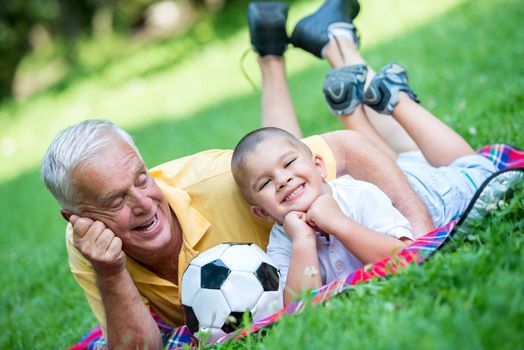 happy grandfather and child have fun and play in park on beautiful  sunny day