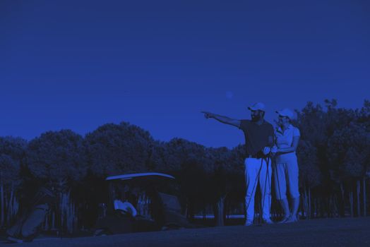 portrait of happy young  couple on golf course duo tone