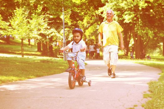 happy grandfather and child have fun and play in park