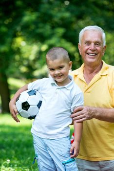 happy grandfather and child have fun and play in park on beautiful  sunny day