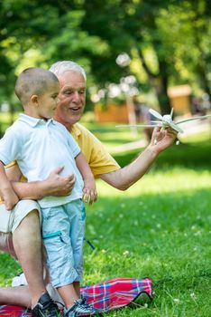 happy grandfather and child have fun and play in park on beautiful  sunny day