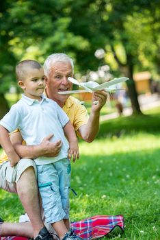 happy grandfather and child have fun and play in park on beautiful  sunny day