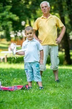 happy grandfather and child have fun and play in park on beautiful  sunny day