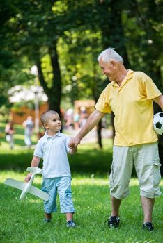 happy grandfather and child have fun and play in park on beautiful  sunny day