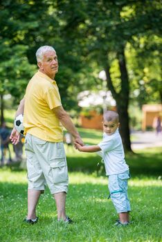 happy grandfather and child have fun and play in park on beautiful  sunny day