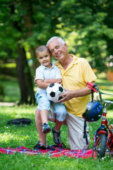 happy grandfather and child have fun and play in park on beautiful  sunny day