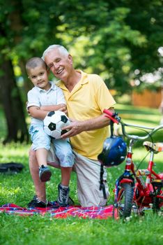 happy grandfather and child have fun and play in park on beautiful  sunny day