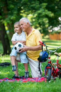 happy grandfather and child have fun and play in park on beautiful  sunny day