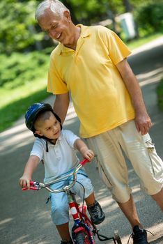 happy grandfather and child have fun and play in park on beautiful  sunny day