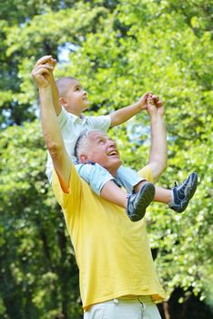 happy grandfather and child have fun and play in park