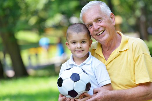 happy grandfather and child have fun and play in park