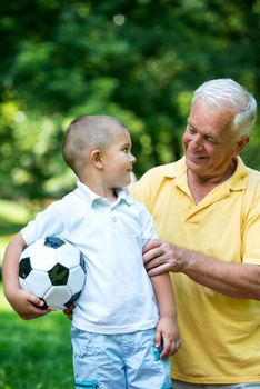 happy grandfather and child have fun and play in park on beautiful  sunny day