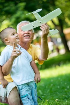 happy grandfather and child have fun and play in park on beautiful  sunny day