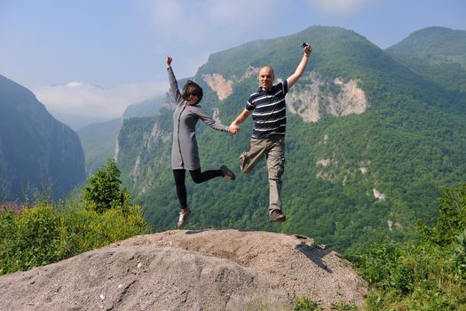 happy young couple in love jump in air in beautiful green and fresh nature