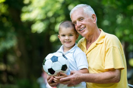 happy grandfather and child have fun and play in park on beautiful  sunny day