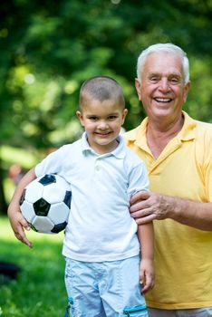 happy grandfather and child have fun and play in park on beautiful  sunny day