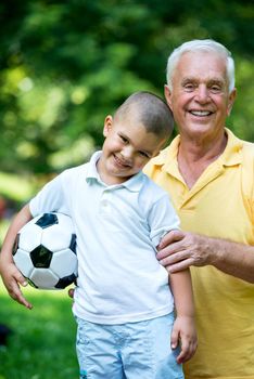 happy grandfather and child have fun and play in park on beautiful  sunny day