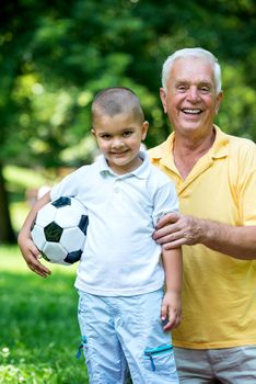 happy grandfather and child have fun and play in park on beautiful  sunny day