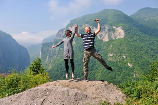 happy young couple in love jump in air in beautiful green and fresh nature