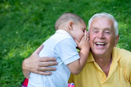 happy grandfather and child have fun and play in park on beautiful  sunny day