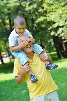 happy grandfather and child have fun and play in park