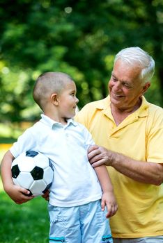 happy grandfather and child have fun and play in park on beautiful  sunny day