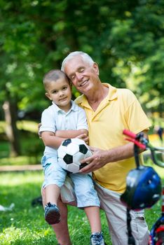 happy grandfather and child have fun and play in park on beautiful  sunny day