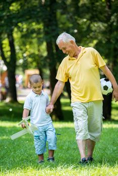 happy grandfather and child have fun and play in park on beautiful  sunny day