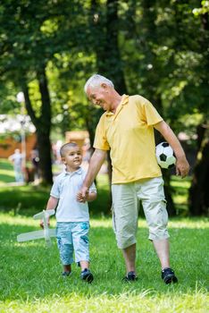 happy grandfather and child have fun and play in park on beautiful  sunny day