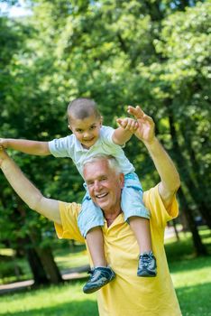 happy grandfather and child have fun and play in park on beautiful  sunny day