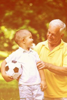 happy grandfather and child have fun and play in park on beautiful  sunny day